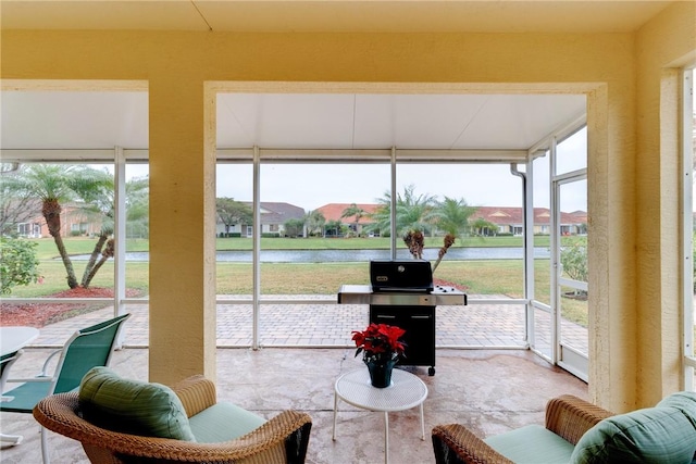 sunroom featuring a water view