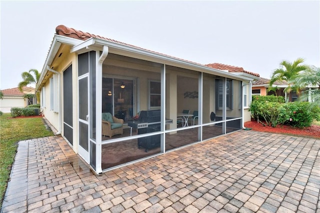 back of property with a sunroom and a patio area