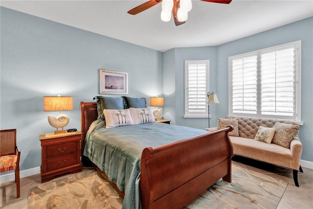 tiled bedroom featuring multiple windows and ceiling fan