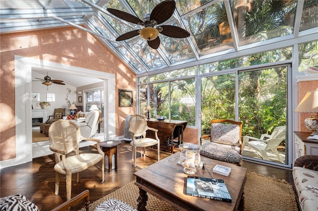 sunroom / solarium with vaulted ceiling, ceiling fan, and a fireplace