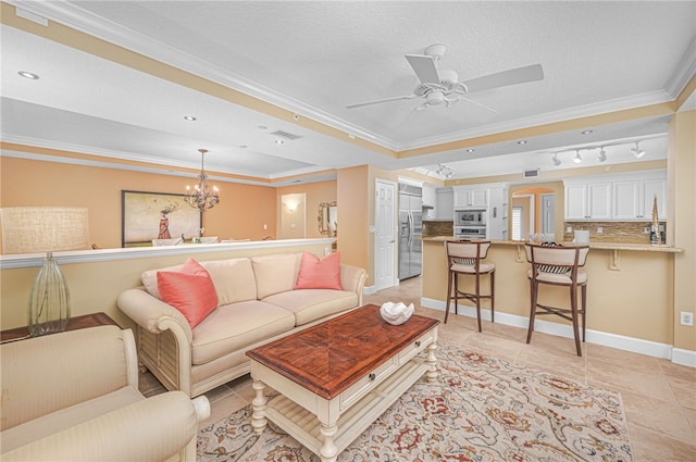 living room with a textured ceiling, light tile patterned floors, baseboards, a tray ceiling, and crown molding