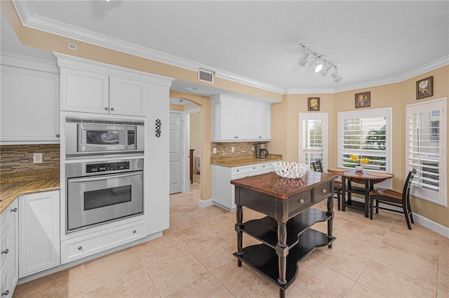 kitchen with visible vents, white cabinetry, stainless steel appliances, and arched walkways