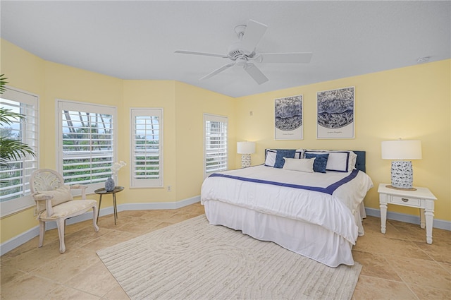 bedroom with ceiling fan, baseboards, and light tile patterned flooring