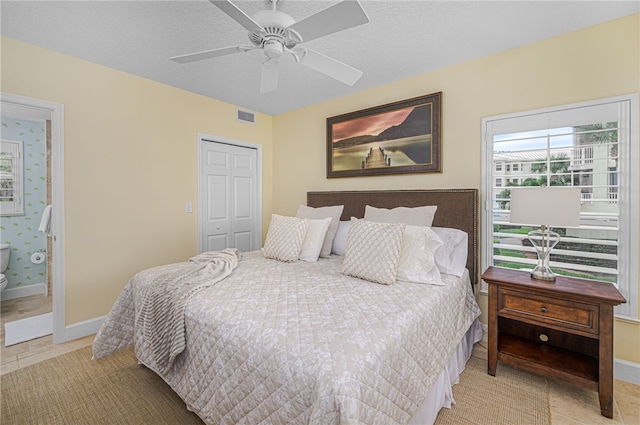 bedroom with a closet, visible vents, a textured ceiling, and baseboards