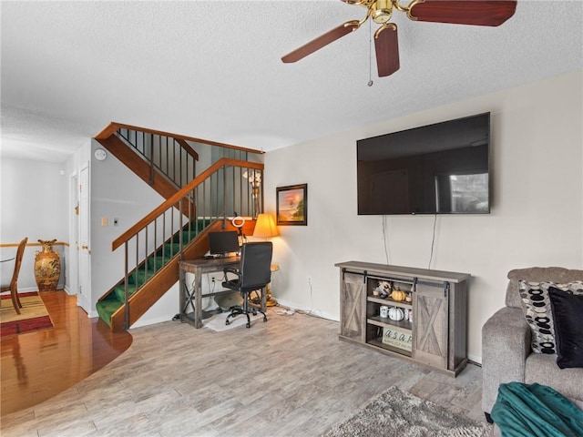 living room with ceiling fan, hardwood / wood-style floors, and a textured ceiling