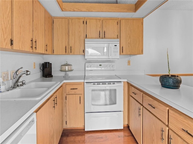 kitchen with sink, light brown cabinetry, white appliances, and light hardwood / wood-style flooring