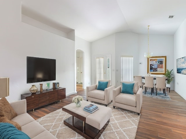 living room featuring high vaulted ceiling, wood-type flooring, and a notable chandelier