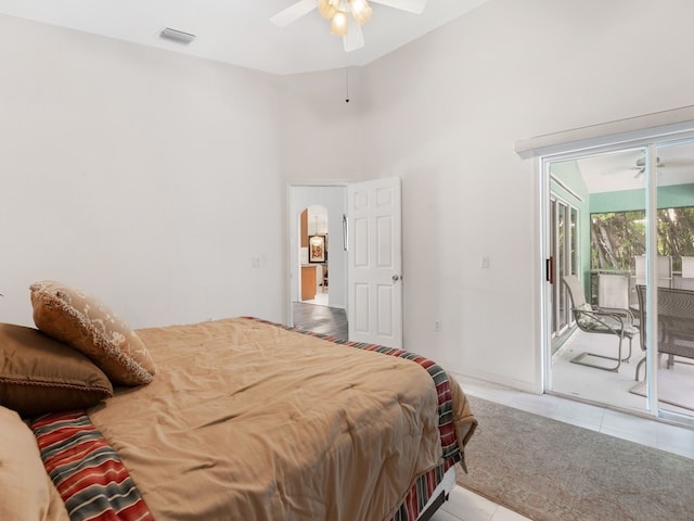 tiled bedroom with ceiling fan, access to exterior, and a towering ceiling