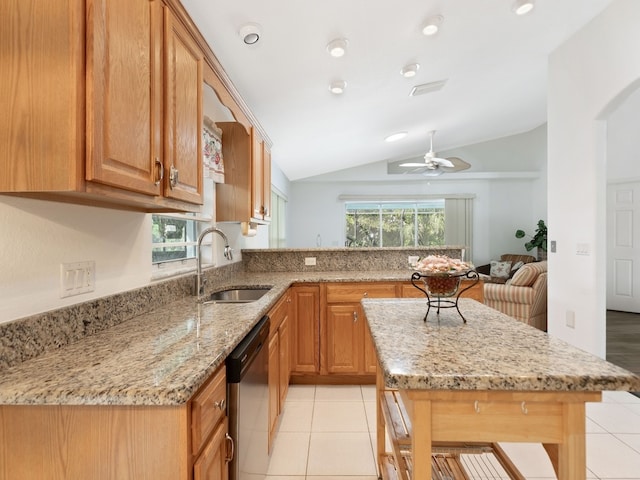 kitchen featuring lofted ceiling, sink, ceiling fan, a breakfast bar, and stainless steel dishwasher