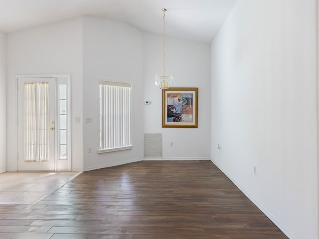 interior space with high vaulted ceiling, dark hardwood / wood-style flooring, and an inviting chandelier