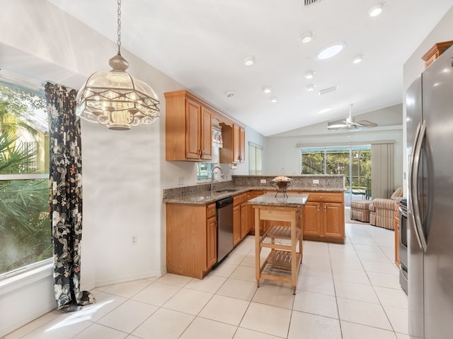 kitchen with lofted ceiling, ceiling fan, decorative light fixtures, stainless steel appliances, and stone countertops