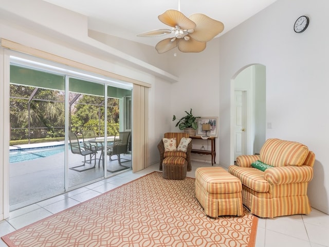 sitting room featuring ceiling fan, vaulted ceiling, light tile patterned flooring, and a swimming pool