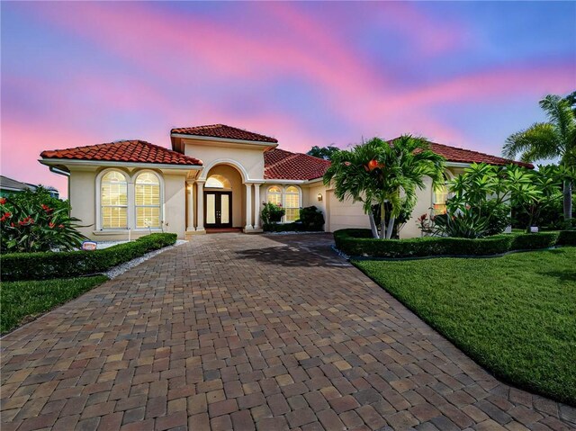 4440 Jacqueline Mnr SW, Vero Beach, FL 32968 - mediterranean / spanish-style house featuring french doors, decorative driveway, an attached garage, and stucco siding