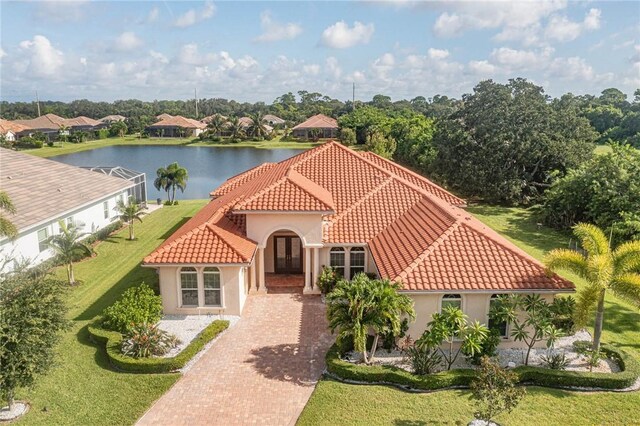 4440 Jacqueline Mnr SW, Vero Beach, FL 32968 - mediterranean / spanish house featuring a tile roof, french doors, stucco siding, and a front lawn