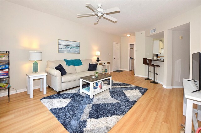 living room with hardwood / wood-style floors and ceiling fan