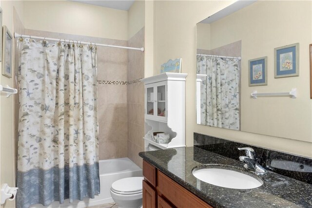 full bathroom with shower / tub combo with curtain, vanity, and toilet