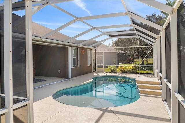 view of swimming pool featuring a lanai and a patio area