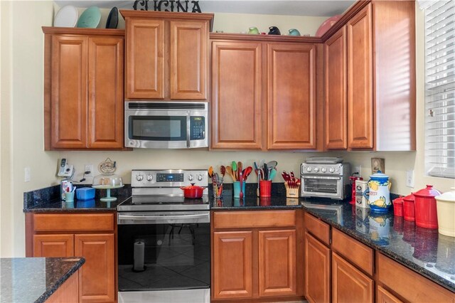 kitchen featuring appliances with stainless steel finishes and dark stone countertops