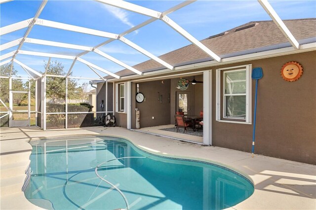 view of swimming pool featuring glass enclosure and a patio area