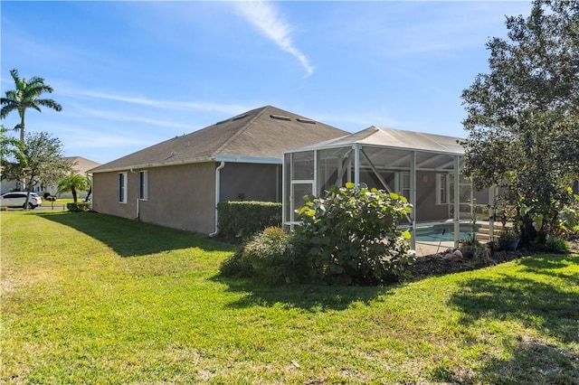 back of property featuring a lawn and glass enclosure