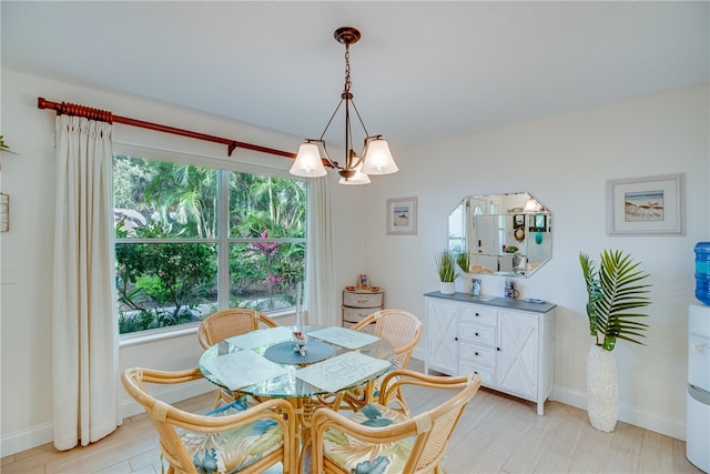 dining space with light hardwood / wood-style floors, a chandelier, and a healthy amount of sunlight