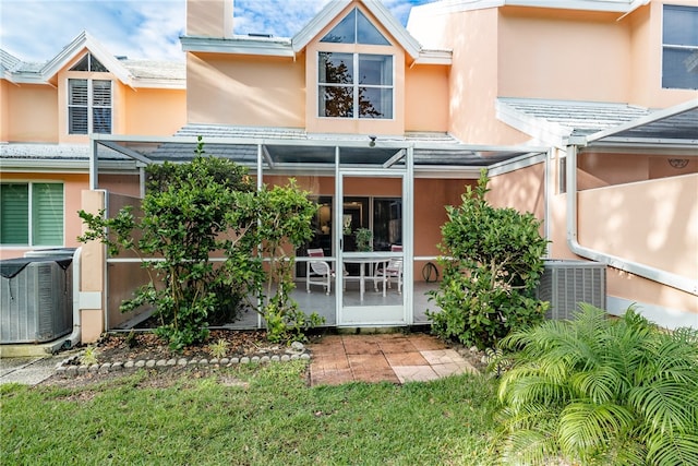 rear view of house featuring a patio, a yard, and cooling unit