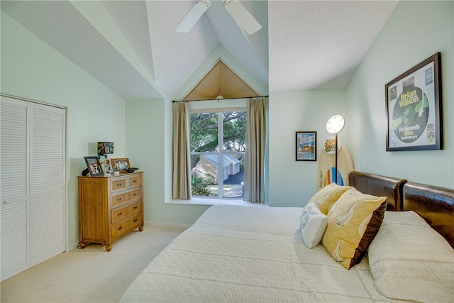 bedroom with light colored carpet, lofted ceiling, a textured ceiling, ceiling fan, and a closet