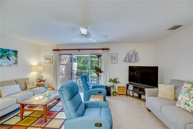 living room featuring a textured ceiling, light hardwood / wood-style floors, and ceiling fan