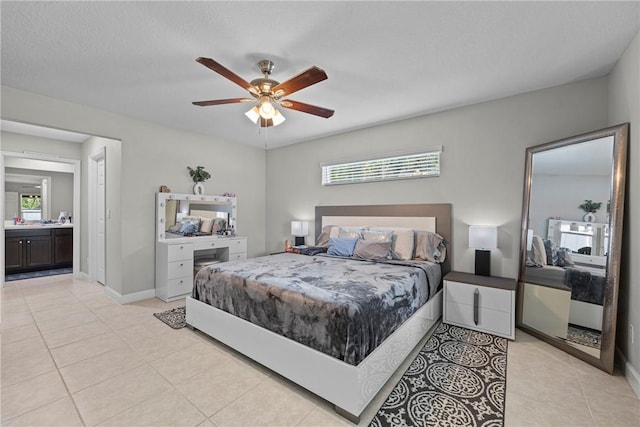 bedroom featuring light tile patterned floors, ensuite bath, and ceiling fan