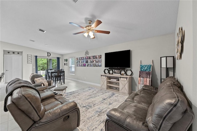 living room featuring lofted ceiling, ceiling fan, and light tile patterned floors