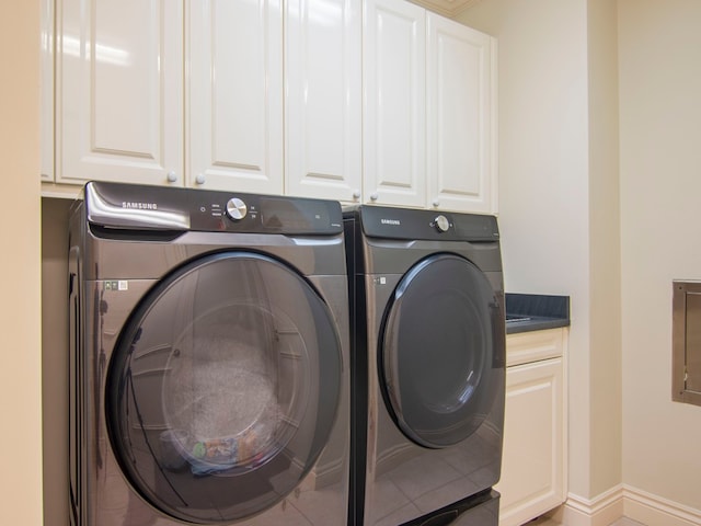 laundry room featuring washer and clothes dryer and cabinets