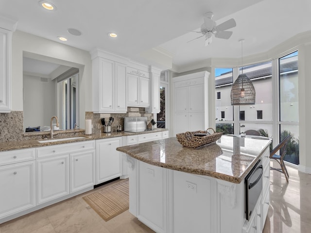 600 Beachview Dr Unit 3N, Vero Beach, FL 32963 - kitchen with a sink, a center island, white cabinetry, a warming drawer, and a ceiling fan