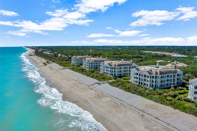 birds eye view of property featuring a water view and a beach view