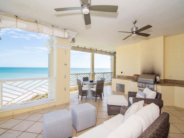 interior space with ceiling fan, a water view, and light tile patterned flooring