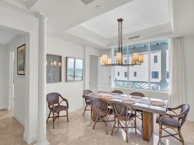 dining area featuring decorative columns, a tray ceiling, a notable chandelier, and plenty of natural light