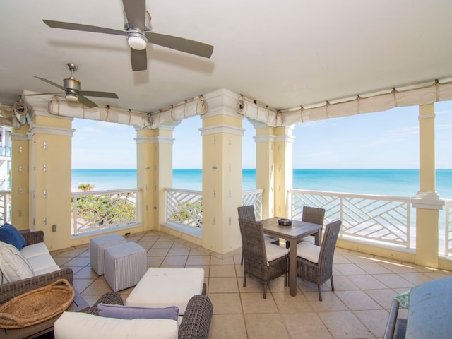 sunroom featuring a water view, a beach view, and ceiling fan