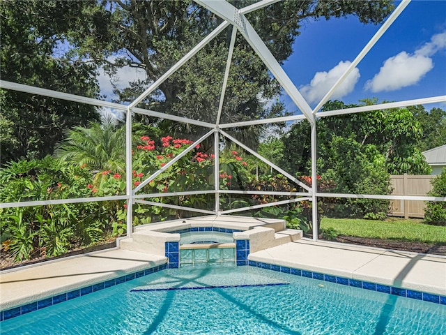 view of pool with glass enclosure and an in ground hot tub