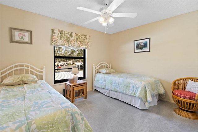 carpeted bedroom with a ceiling fan and baseboards