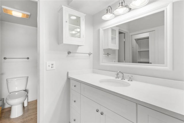 bathroom with toilet, wood finished floors, and vanity