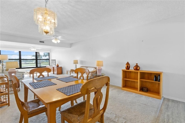 dining room with visible vents, a ceiling fan, a textured ceiling, light wood-type flooring, and baseboards