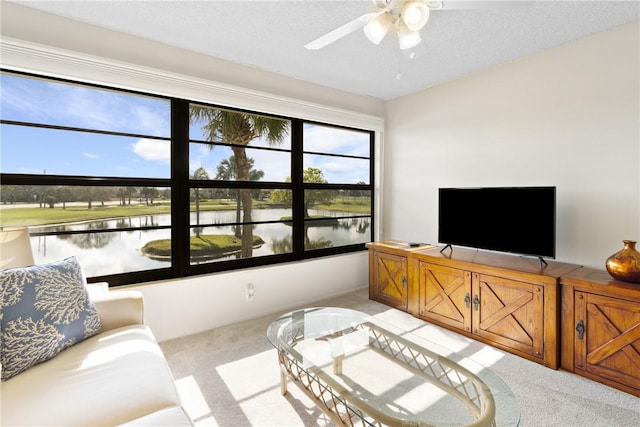 living room featuring light carpet, ceiling fan, and a textured ceiling