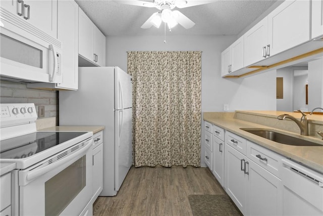 kitchen with ceiling fan, wood finished floors, a sink, white cabinets, and white appliances