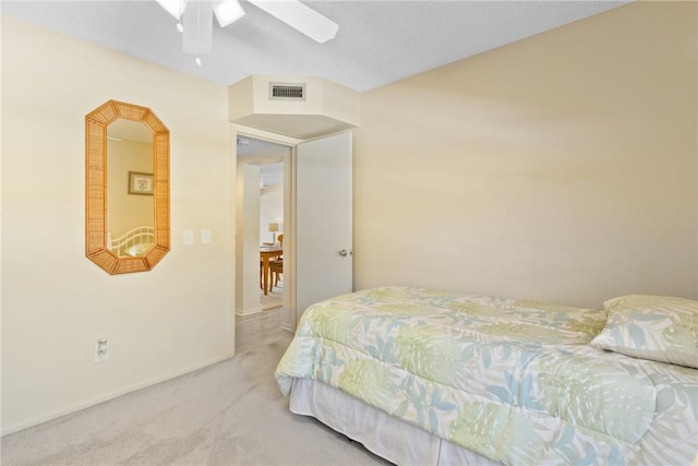 carpeted bedroom with a ceiling fan and visible vents