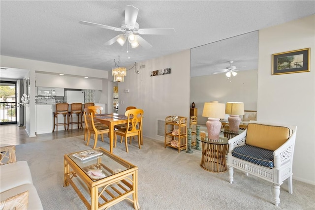 carpeted living room featuring a ceiling fan, visible vents, and a textured ceiling