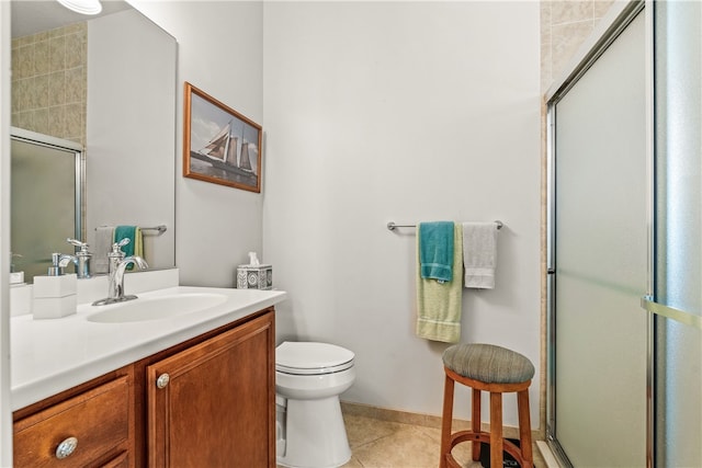 bathroom featuring tile patterned flooring, vanity, toilet, and a shower with shower door