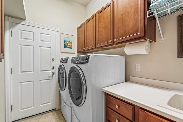 laundry area with independent washer and dryer, cabinets, light tile patterned floors, and sink