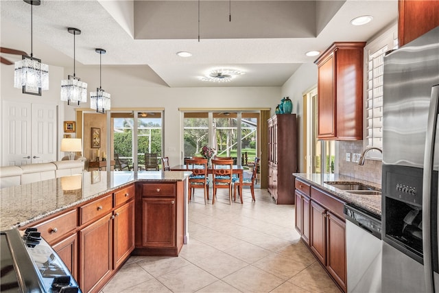 kitchen featuring an inviting chandelier, hanging light fixtures, decorative backsplash, a textured ceiling, and stainless steel appliances