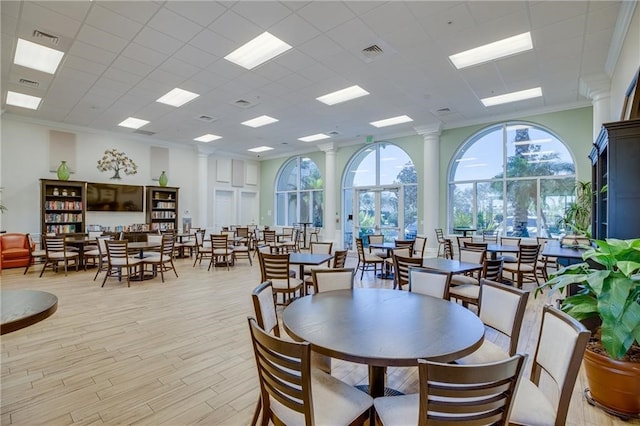 dining space featuring a paneled ceiling, light wood-type flooring, and crown molding