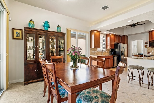 tiled dining area featuring ceiling fan and sink