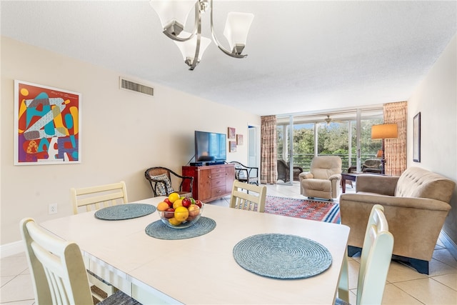 dining area featuring an inviting chandelier, a textured ceiling, and light tile patterned floors